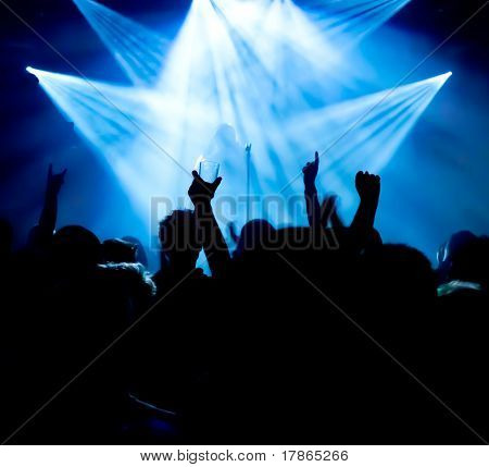 silhuetter af koncert crowd foran lyse scenelys
