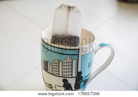 Closeup teabag put in white and blue ceramic mug