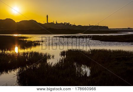 El Rompido lighthouse and marina at sunrise from marshlands Huelva Spain