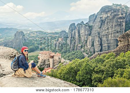 Adult happy woman traveler enjoys landscape with volcanic mountains. Meteora monasteries Greece.