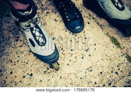 Closeup of man guy putting on roller skates outdoor.