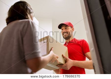 delivery, mail, people and shipping concept - happy man delivering parcel box to customer home