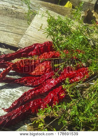 Red pepper on wooden boards with greens