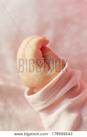 Closeup of Cute Little Baby Hand. Selective Focus. Pink Background.