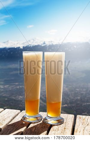 Tasty beautiful cold beer on a wooden table on mountain background. Beautiful landscape. Alps mountains. Austria.