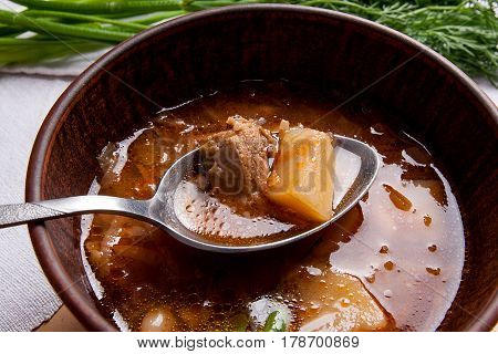 Close Up View Of Clay Plate And Spoon With Red Beetroot Soup Or Borsch On Wooden Background..
