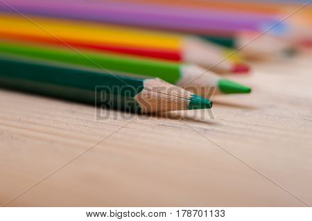 Bright colorful pencils on wooden table. School, sketching and Shallow depth of field.