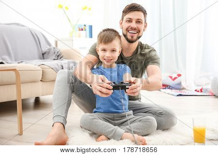 Father and son playing videogame at home