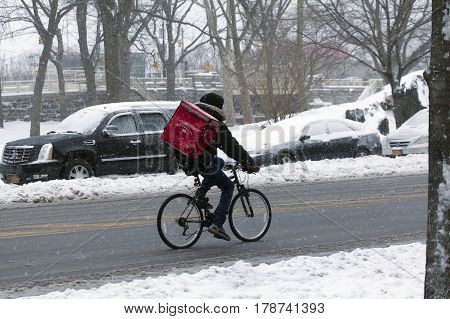 BRONX NEW YORK - MARCH 14: Person making delivery on bike during snow storm. Taken March 14 2017 in New York.