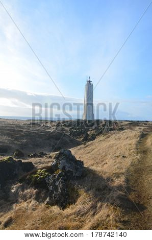 A towering white lighthouse on Snaefelssnes Peninsula in Iceland.