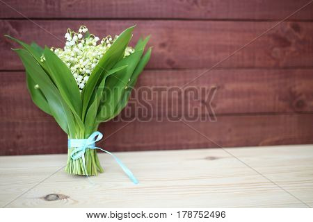 Lily of the valley on wooden background. Lily of the valley bouquet. Lily of the valley with copy space.