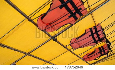 Orange Life Jacket Or Life Vest Hanging On The Roof Boat. Boat Capsized Concept.