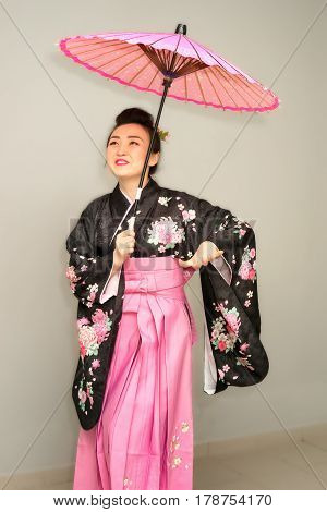 beautiful geisha in traditional japanese kimono with parasol