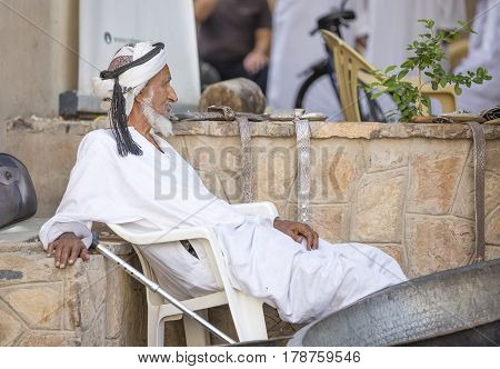 Nizwa Oma 24th March 2017: old Omani man selling old copper cooking dishes at the market