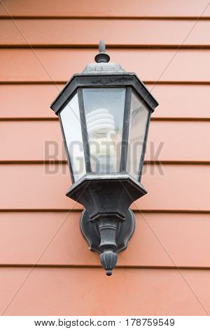 Lamp hanging on brown wooden wall background
