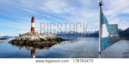Lighthouse Les eclaireurs in Beagle Channel and blurry Argentina flag