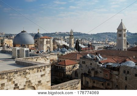 JERUSALEM ISRAEL - MARCH 25 2017: View from above of the old city of Jerusalem. On the right are the gray domes of the Holy Sepulcher Church on the left is the bell tower of Rudimer