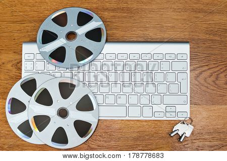 Compact disks in the form of old bobbins lie on the keyboard, on a wooden table next to the keys