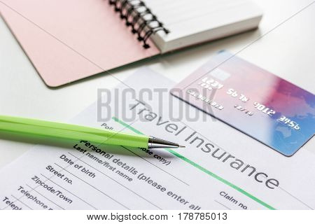 Travel insurance application form with credit cards on white desk background