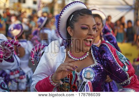 ARICA, CHILE - FEBRUARY 10, 2017: Female members of a Caporales dance group in ornate costumes performing at the annual Carnaval Andino con la Fuerza del Sol in Arica, Chile.