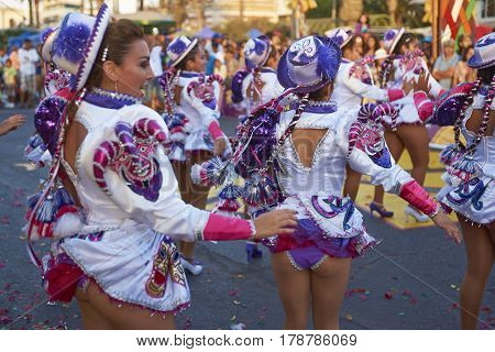 ARICA, CHILE - FEBRUARY 10, 2017: Female members of a Caporales dance group in ornate costumes performing at the annual Carnaval Andino con la Fuerza del Sol in Arica, Chile.