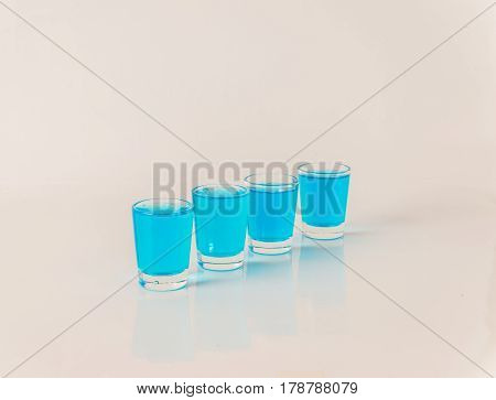 Four Glasses Of Blue Kamikaze, Glamorous Drink, Mixed Drink Poured Into Shot Glasses