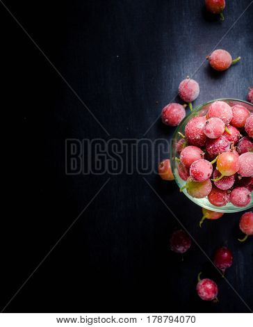 Frozen And Fresh Berries In A Glass Pial On A Black Background.