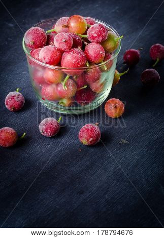 Frozen And Fresh Berries In A Glass Pial On A Black Background.