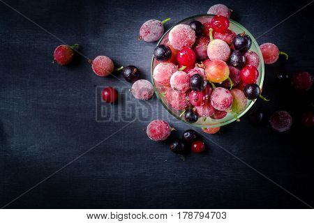 Frozen And Fresh Berries In A Glass Pial On A Black Background.