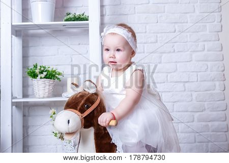 Little girl on horseback in white dress