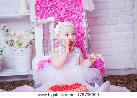 Little girl eating cake in white dress