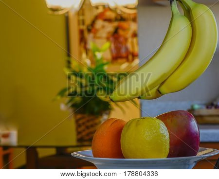 Bowl with fruit and banana's hanging over