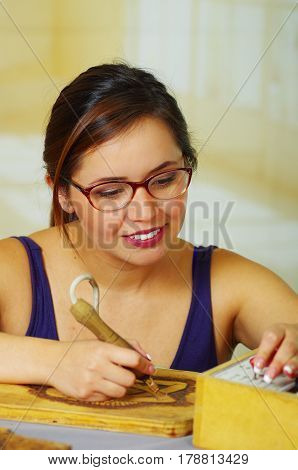 Beautiful young woman wood burning with pyrography pen