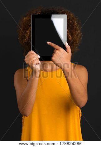 Beautiful African American woman holding and showing something on a tablet