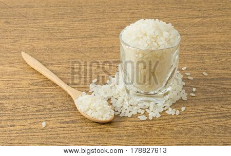 Japanese Cuisine Raw and Uncooked Japanese Rice in A Wooden Spoon and A Tumbler.