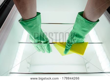 Man's Hand Cleaning The Kitchen Fridge