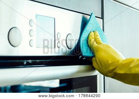 Man's Hand Cleaning The Kitchen Oven