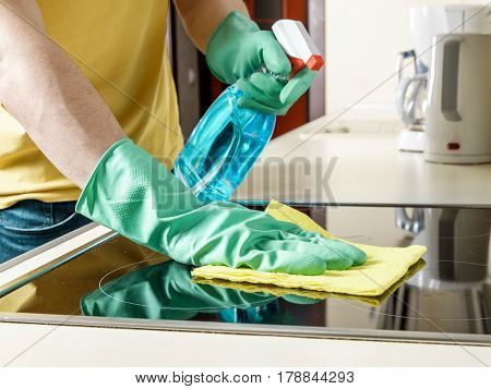 Man Cleaning The Cooker In The Kitchen