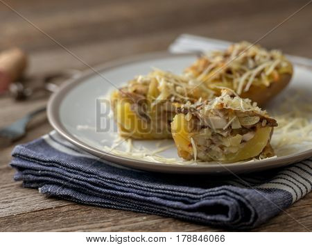 Served potion of baked potato stuffed with mushrooms and plenty of cheese, blue towel