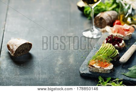 Tasty rye bread sandwiches with salmon, avocado, beetroot, creamcheese, ham, herbs and spices