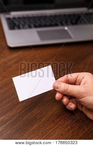 Hand hold blank business card design mockup. Businessman holding visiting card. Business branding template. Person in suit and white shirt.