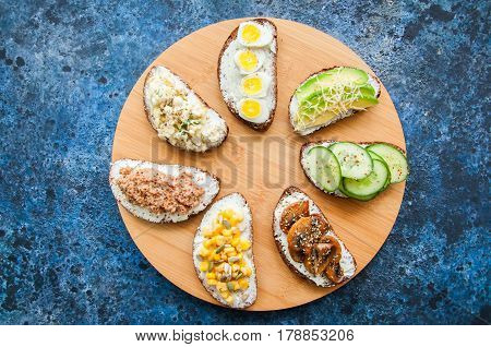 Mix Of Rye Bread Bruschettas With Various Filling. Sweet Corn Avocado Mashrooms Quail Eggs Cucumber