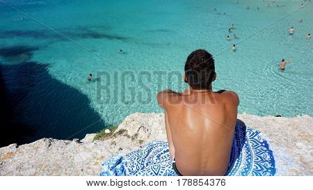 Boy in front of a crystal clear beach in Menorca