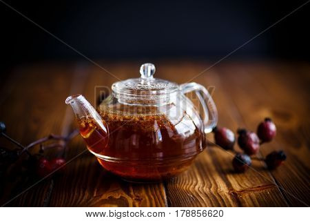 Dried red rose hips and tea on a black background