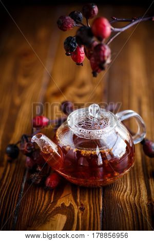 Dried red rose hips and tea on a black background