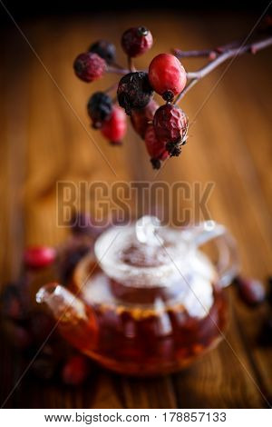 Dried red rose hips and tea on a black background
