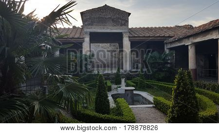 Garden with fountain surrounded by ruins of a house