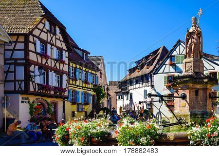 Eguisheim France-June 23 2016: Tourists are hanging around the town square of Eguisheim. It is one of the most popular tourist destinations along the famous Alsace Wine Route or another name called Romantic Road