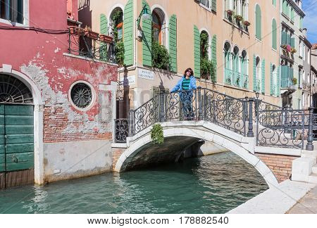 Woman Is Standing On Ponte Giustinian In Venice, Italy