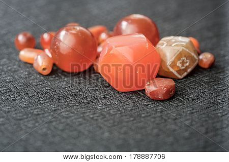 Varieties of ancient carnelian beads on Thai silk background